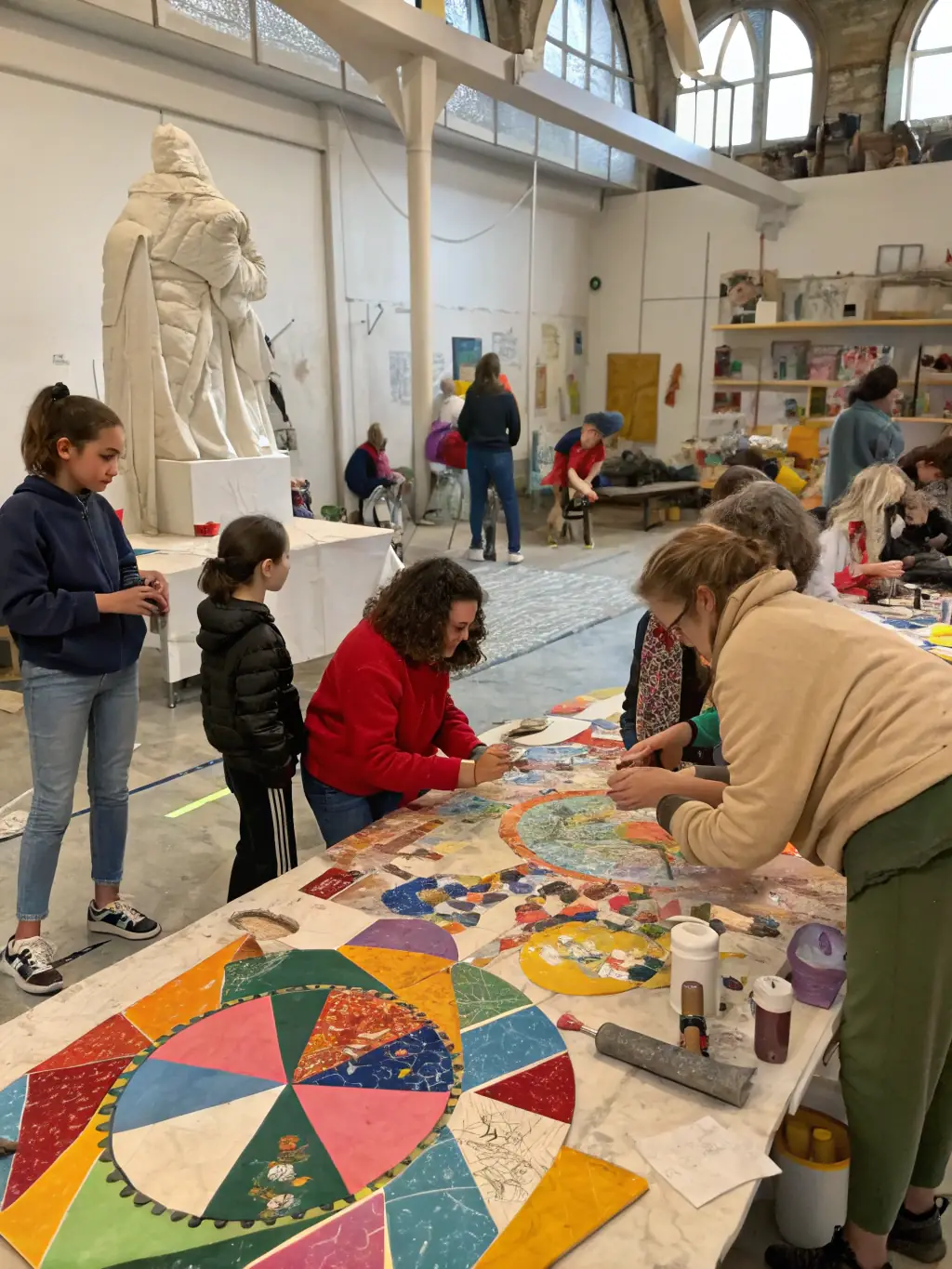 A vibrant photograph capturing a community art workshop in progress, showcasing participants of diverse ages and backgrounds actively engaged in painting and sculpting, reflecting COMITE YAKAMOTO's commitment to accessible art education.